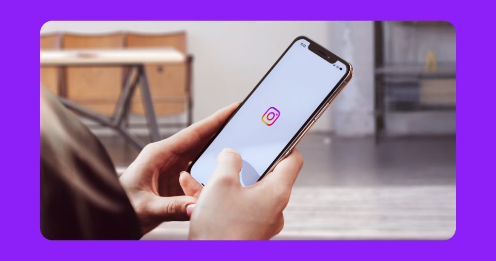 677bf47e6a21714f5ea59561_A person using a cellphone showing the Instagram logo with a white background