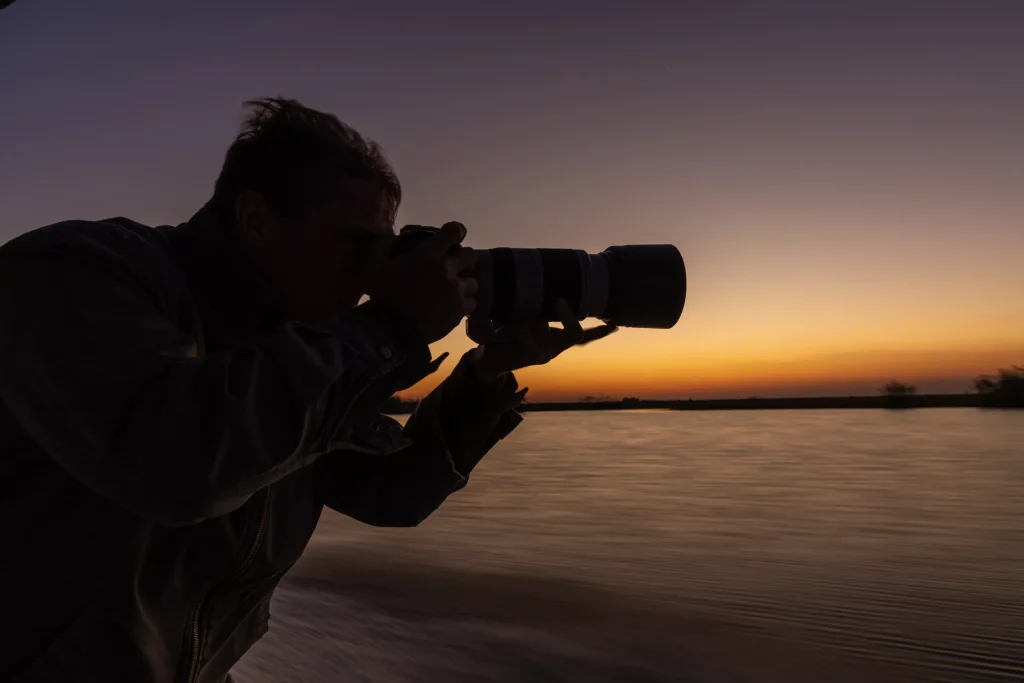 Guest-with-camera-gear-on-safari-in-Botswana-Pangolin-Photo-Safaris-scaled